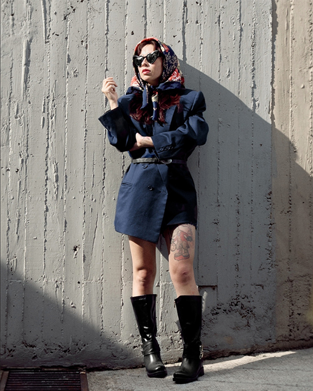 Black and white photograph nun in front of a giant window, holding an owl in her hand.