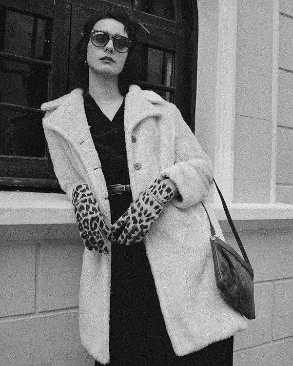 Fotografía retrato en blanco y negro de una modelo con las manos en el rostro.