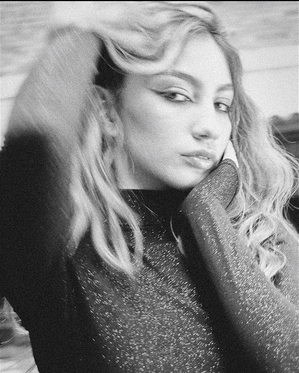 Fotografía de mujer en una alfombra con los pantalones desabrochados.